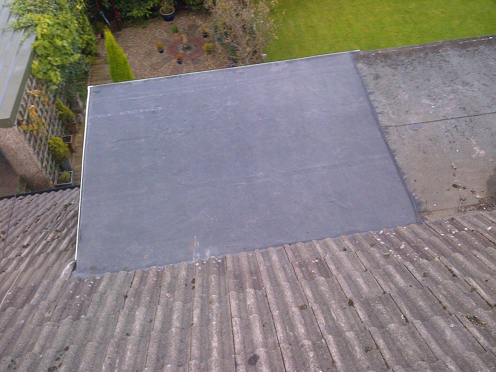 New dark gray rubber membrane on a small flat roof, seen from above
