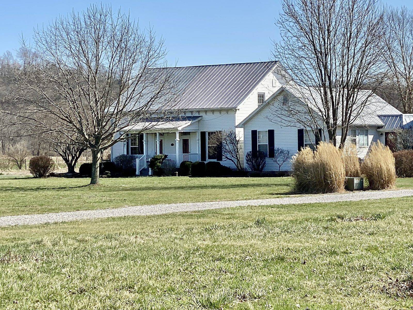 White farmhouse with a gray standing seam metal roof