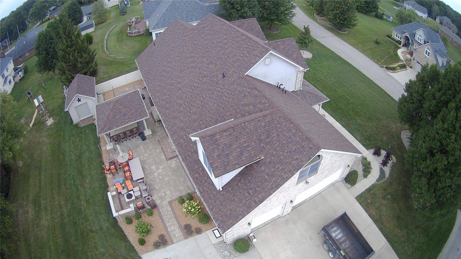 Brown shingle roof seen from a drone, with a new ridge cap along the peak
