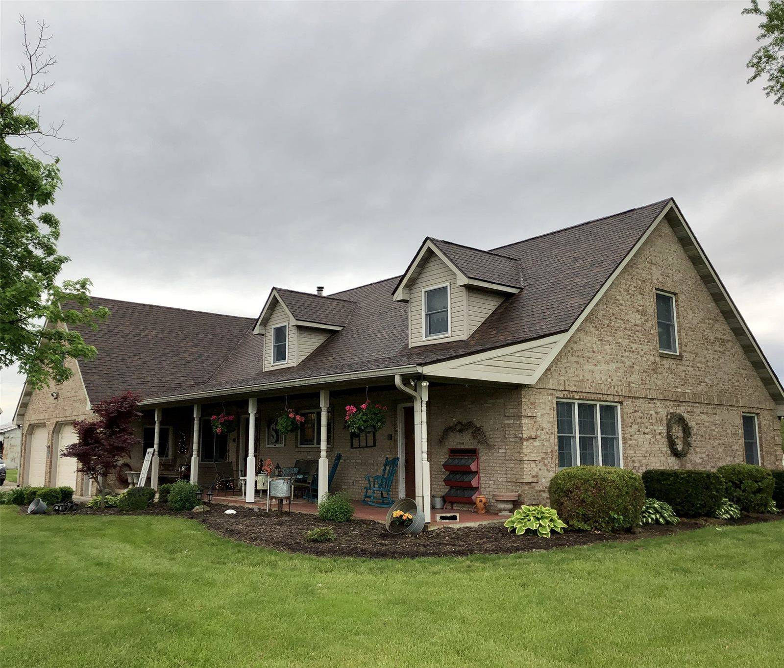 Brick house with two dormers and a new brown architectural shingle roof